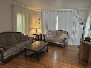Ein Wohnzimmer mit einer Couch, einem Couchtisch, einer Lampe und einem Sessel.