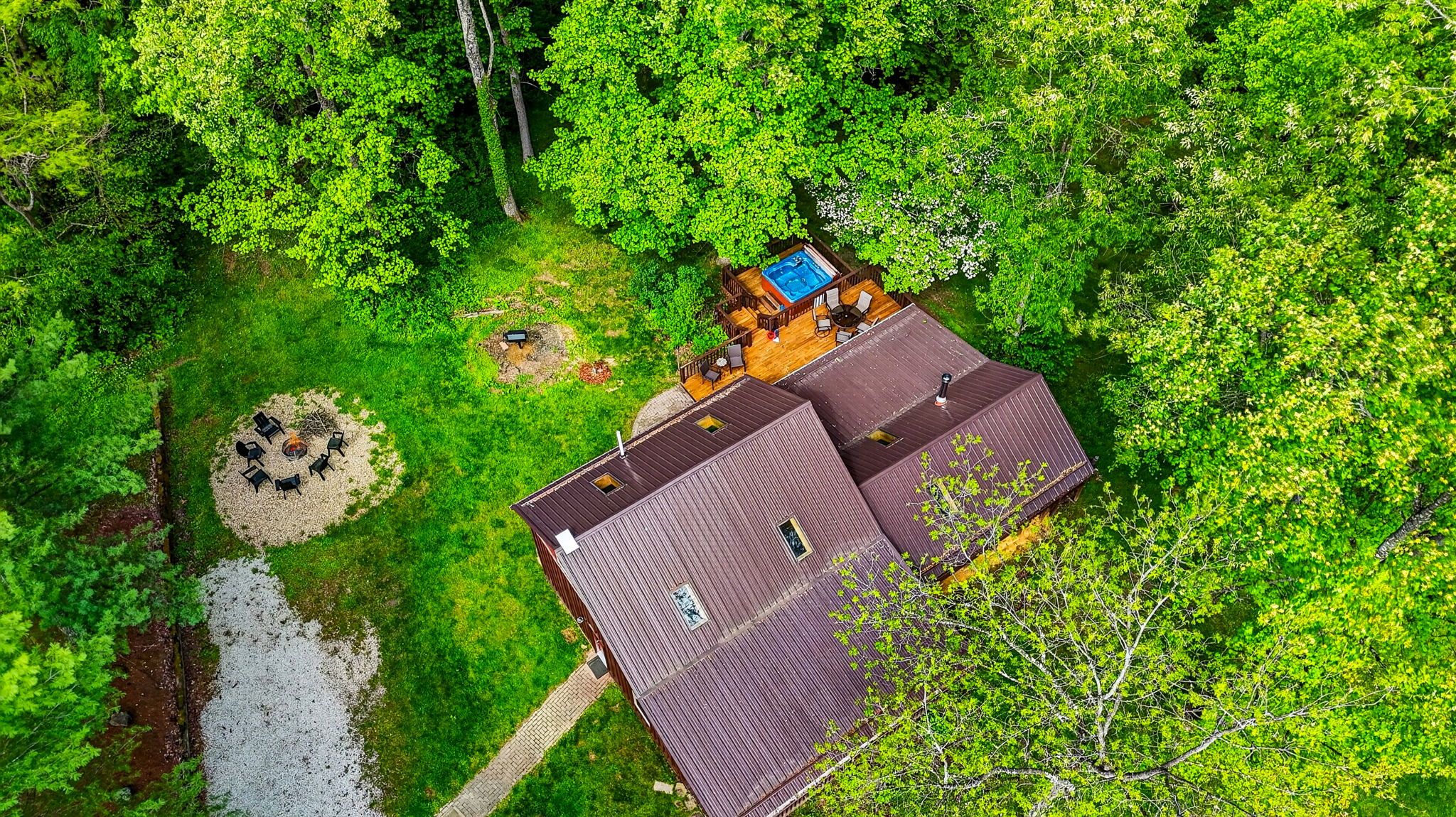 A house with a swimming pool, surrounded by dense greenery.