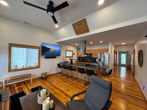 A modern kitchen with a large island, wooden cabinets, and a built-in oven. - Tulip Tree House in Shorewood-Tower Hills-Harbert, Michigan (Shorewood-Tower Hills-Harbert)