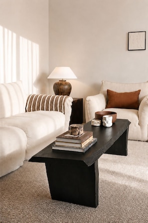 A living room with a black coffee table, two white sofas, a lamp, and a framed picture on the wall. - The Cabbage Palm | Coastal Escape |
150m from Kiama's Main Street (Kiama)