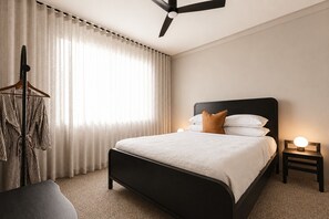 A bedroom with a bed, bedside table, and a hanging rack. - The Cabbage Palm | Coastal Escape |
150m from Kiama's Main Street (Kiama)