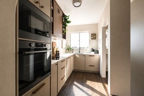 A kitchen with a built-in oven, microwave, and a window with a view. - The Cabbage Palm | Coastal Escape |
150m from Kiama's Main Street (Kiama)