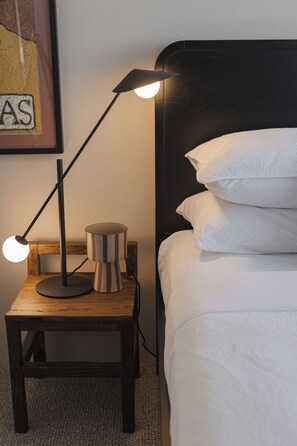 A bed with white bedding, a wooden nightstand with a lamp, and a framed picture on the wall. - The Cabbage Palm | Coastal Escape |
150m from Kiama's Main Street (Kiama)