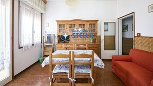 A room with a bunk bed, a red sofa, a wooden cabinet, and a television. - Accogliente # trilocale 100mt from the sea# (Jesolo)