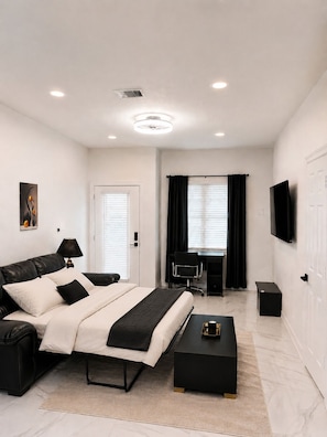 A modern bedroom with a bed, desk, chair, and TV. - FIFA World Cup ‘26! 2 Bedroom, 2.5 Bath (Houston)