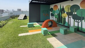 A rooftop play area with a climbing wall, a slide, and a mural with trees and the text 'LET'S PLAY'. - Aparts4Days 2 Bedroom Apartment 4405 (Miraflores)