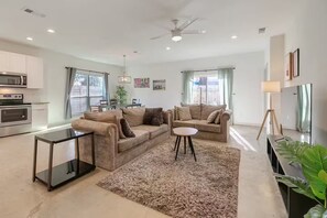 Un salon moderne avec un canapé, une table basse et un meuble pour la télévision.