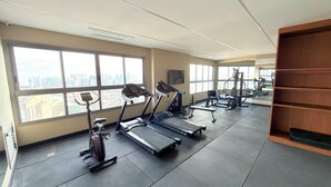 Un gimnasio con cintas de correr, elípticas y equipo de pesas.
