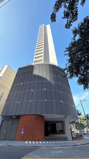 A modern building with a tall central tower and a curved facade. - Stay Refuge | Your retreat just minutes from the airport (Guarulhos)