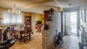 Un comedor con una araña, una chimenea y una mesa con sillas.