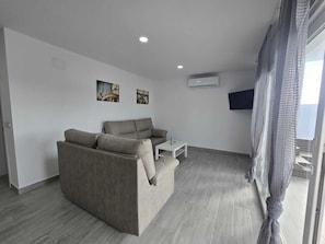 A modern living room with a sofa, a coffee table, and artwork on the wall. - Beautiful new house with private pool (Conil De La Frontera)