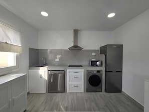 A compact kitchen with a dishwasher, washing machine, microwave, and refrigerator. - Beautiful New House with a Private Pool (Conil De La Frontera)