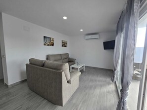 Ein modernes Wohnzimmer mit einer Couch, einem Couchtisch und Kunstwerken an der Wand.