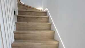 Eine Holztreppe mit weißen Wänden und modernem Design.