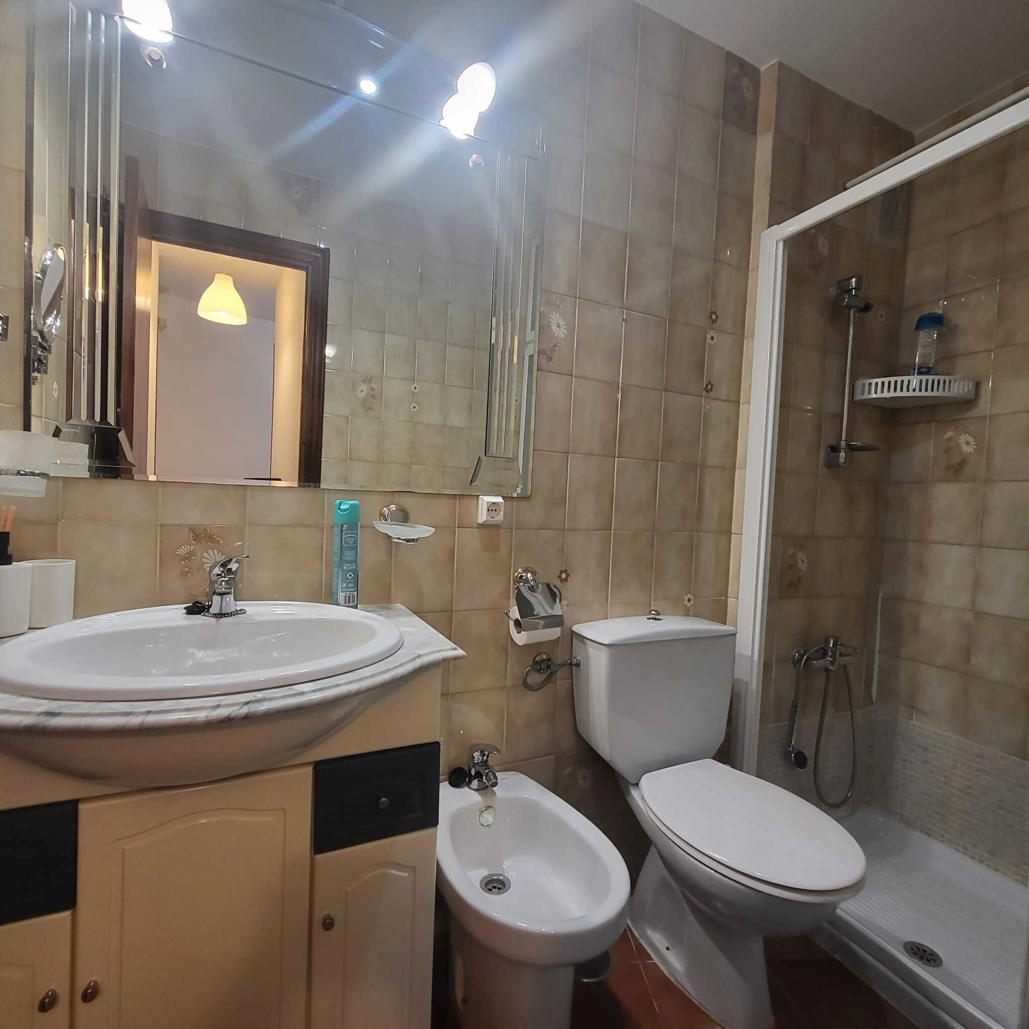 Une salle de bain équipée d’un lavabo, d’un bidet, de toilettes et d’une douche.