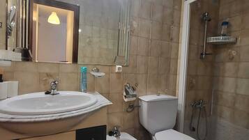 Une salle de bain équipée d’un lavabo, d’un bidet, de toilettes et d’une douche.