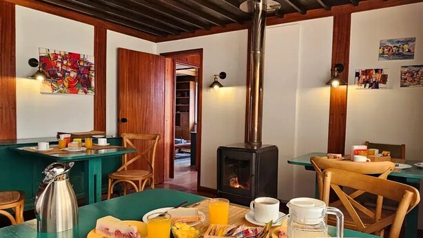 A breakfast setup with a coffee pot, juice, toast, and a fruit bowl on a table. - Hotel Casa Ellies Boutique (Puerto Varas)