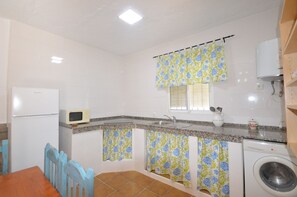 A compact kitchen with a refrigerator, microwave, sink, and washing machine. - Samuel house with community pool and porch (Conil De La Frontera)