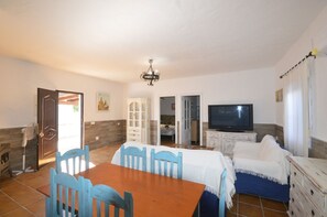 A room with a dining table, chairs, a television, a bed, and a wardrobe. - Samuel house with community pool and porch (Conil De La Frontera)