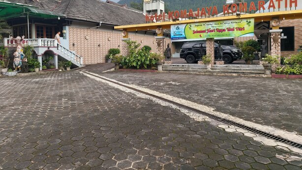 A hotel entrance with a signboard, a staircase, and a paved area. - Hotel O near Tawangmangu Wonder Park for (Tawangmangu)