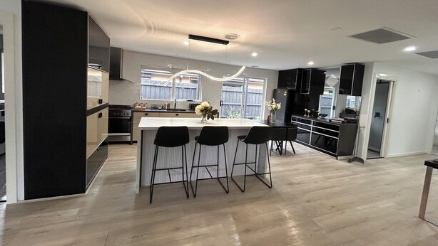A modern kitchen with a central island, bar stools, and a dining area. - Beautiful 4 bedroom for short or long term stay! (Hastings)