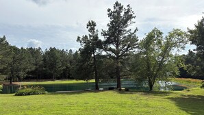 A golf course with a pond, surrounded by trees and a well-maintained lawn. - Shawnee Pines #3 - Cozy Cabin (Golconda)