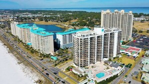 Ein Hochhaus-Hotel mit mehreren Balkonen, einem Schwimmbad und Blick auf den Strand.