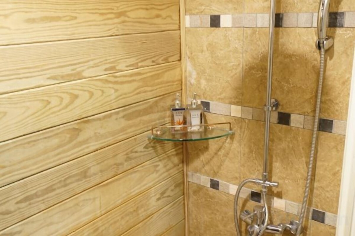 Una pared de madera con un estante de vidrio que sostiene artículos de aseo.