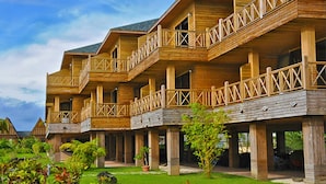 Un immeuble en bois à plusieurs étages, doté de balcons et d’un espace jardin.