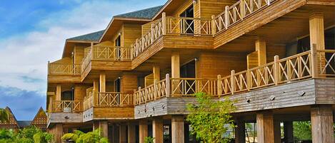 Un edificio de madera de varios pisos con balcones y un jardín.