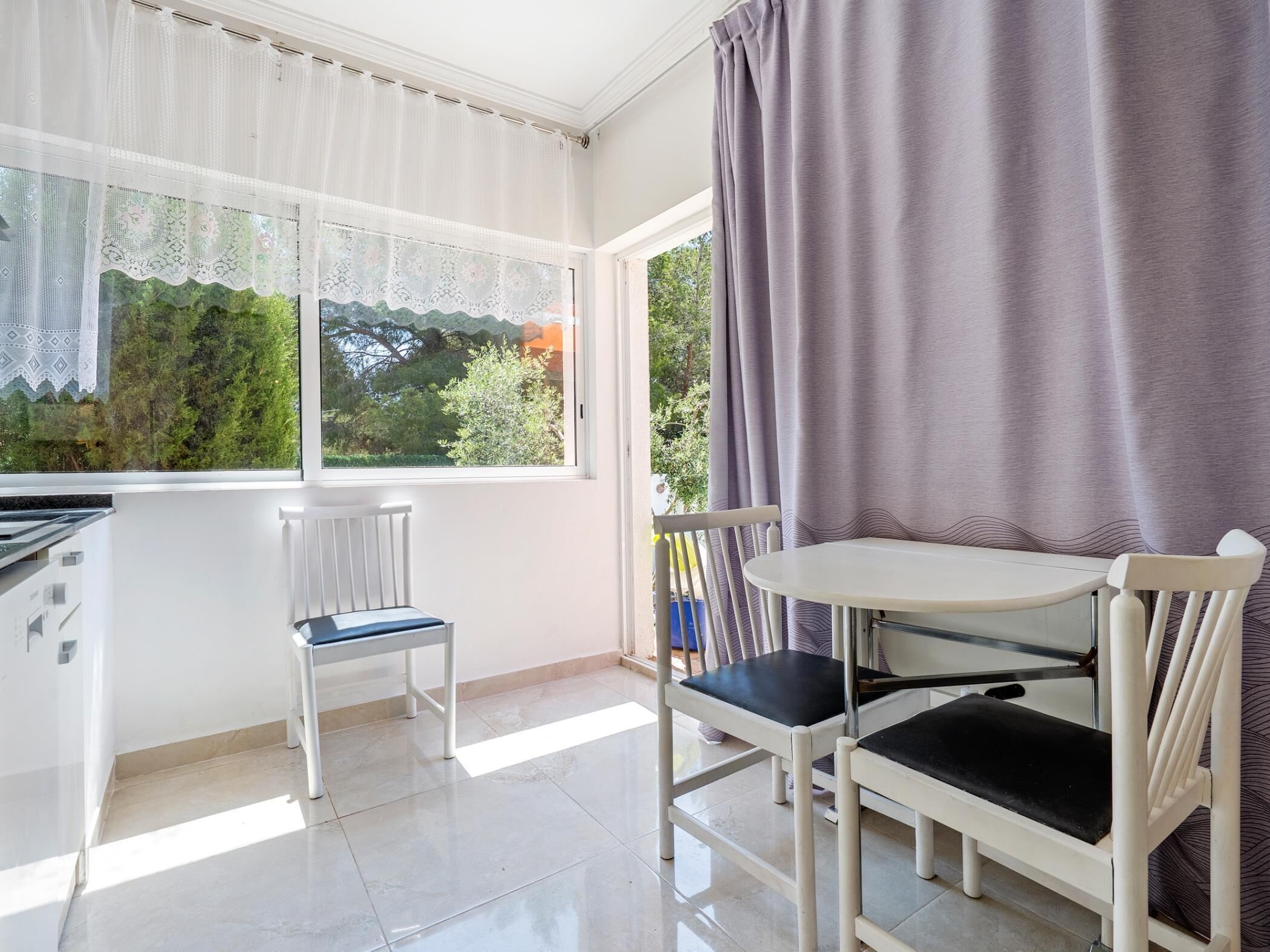 A room with a window, a table, two chairs, and a radiator.