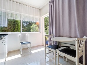 A room with a window, a table, two chairs, and a radiator. - Private pool house, barbecue and petanque (L'Ametlla de Mar)