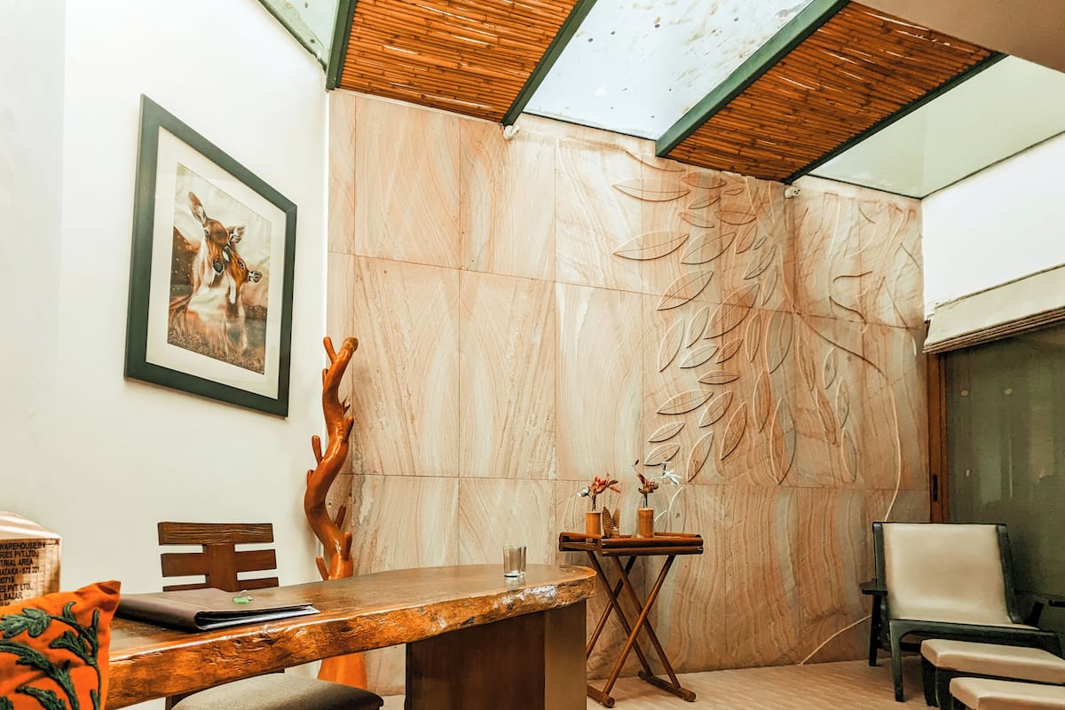 A modern interior with a wooden table, chairs, a framed picture, and a decorative wall.