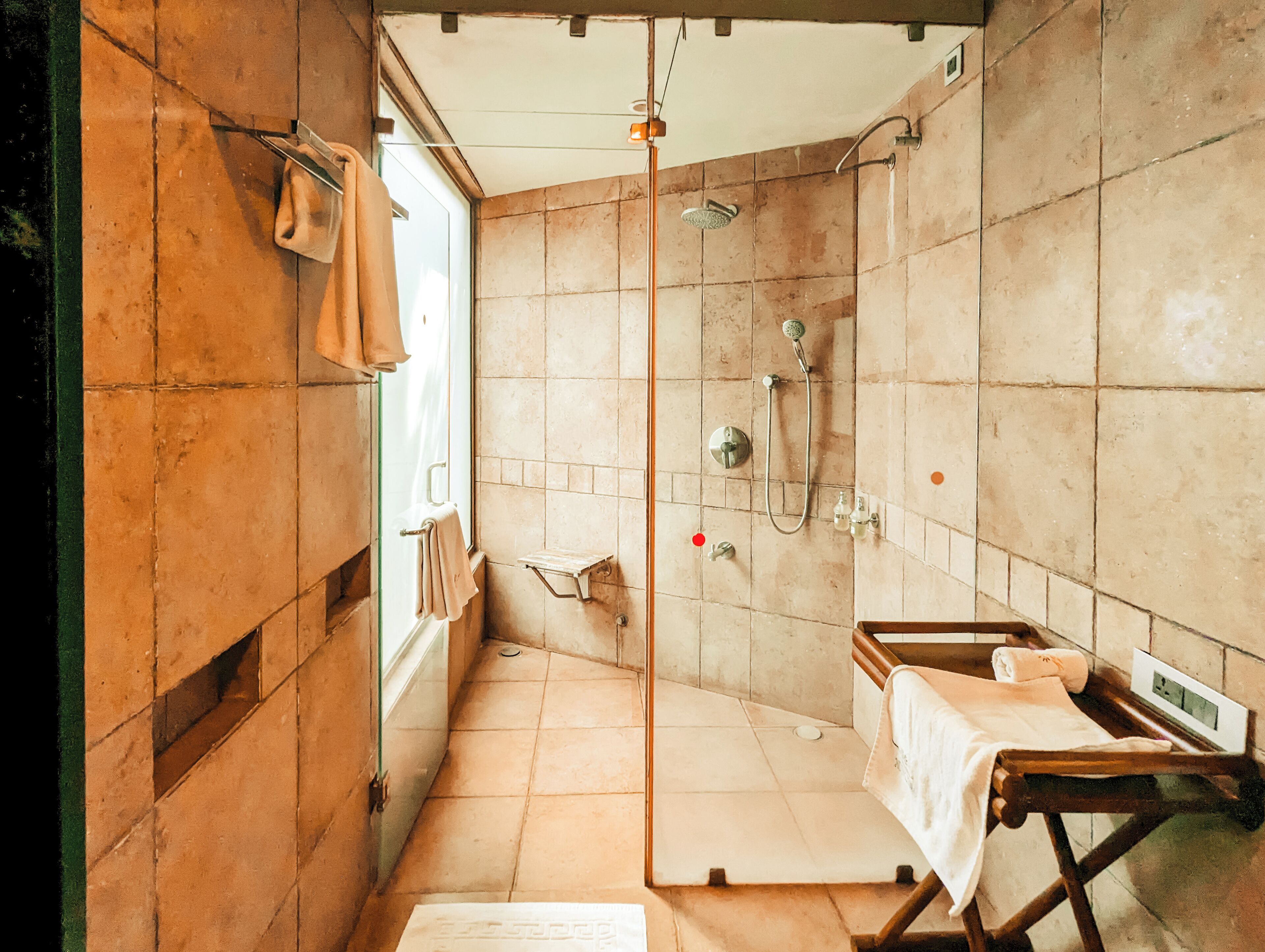 Un baño con ducha, lavamanos y un perchero para toallas.