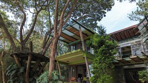 A multi-story building with a treehouse, surrounded by lush greenery. - Waterwoods Lodge Kabini (Heggadadevankote)