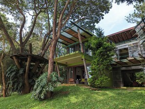 A multi-story building with a treehouse, surrounded by lush greenery. - Waterwoods Lodge Kabini (Heggadadevankote)