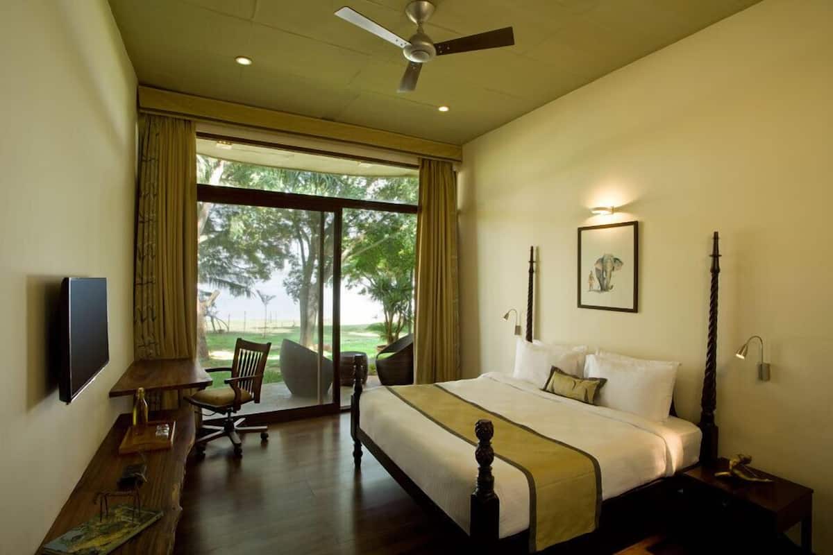 A hotel room with a bed, desk, chair, and a television.