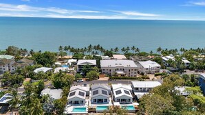 Una zona residenziale sulla costa, con case, una piscina e vista sull'oceano.