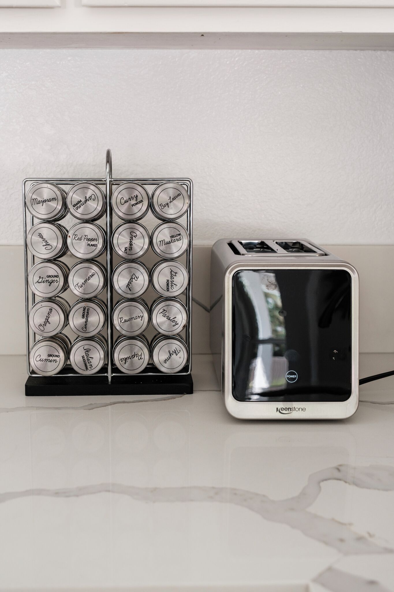 Una cocina con un organizador de especias y un tostador.