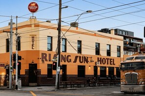 Ein Gebäude mit einem Schild, auf dem 'RING SUN HOTEL' steht, und einem 'Carlton DRAUGHT'-Schild darüber.