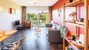 Un salon moderne comprenant un canapé, une table à manger, des chaises et un balcon avec vue.