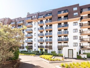 A multi-story residential building with balconies, a gated entrance, and landscaped areas. - Charming apartment close to the the beach (Sint-Idesbald)