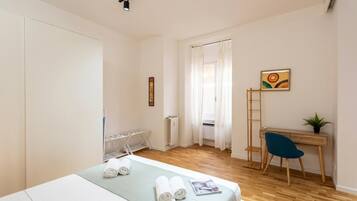 Una camera da letto con un letto, una scrivania, una sedia, un termosifone e una finestra con tende.