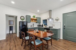 Een moderne keuken met een eettafel, stoelen en een koelkast.