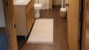 Un bagno piccolo e funzionale con lavandino, water e tenda per la doccia.