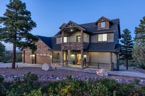 A two-story house with a stone facade, a garage, and a covered porch.