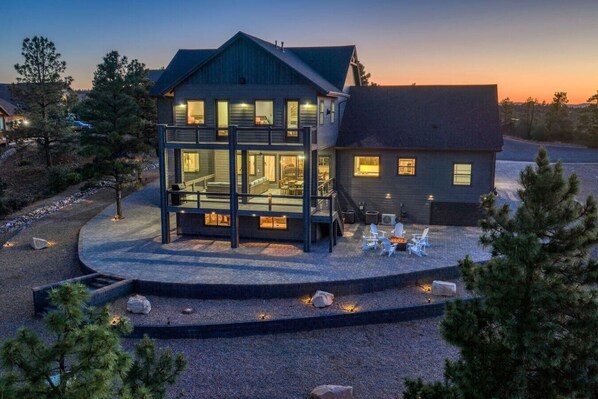 A two-story house with a large deck and outdoor seating area.