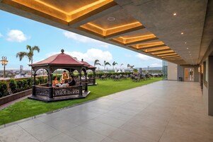 Una terraza en la azotea con un pabellón, zona de estar y vistas panorámicas de la ciudad.