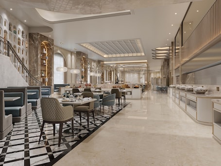 Un moderno vestíbulo de hotel con piso a cuadros, zonas de estar, una escalera y una isla central con bar.. Hotel Express Inn Heritage
