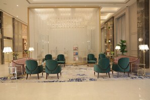 Eine Lobby mit Sitzgelegenheiten, einer Wandgestaltung und einer Rezeption.